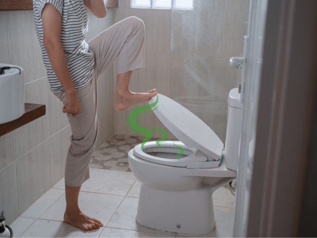 A person lifts a toilet seat with their bare foot