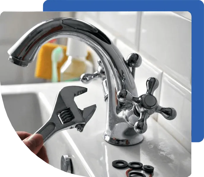 Hand with wrench fixing a chrome faucet.