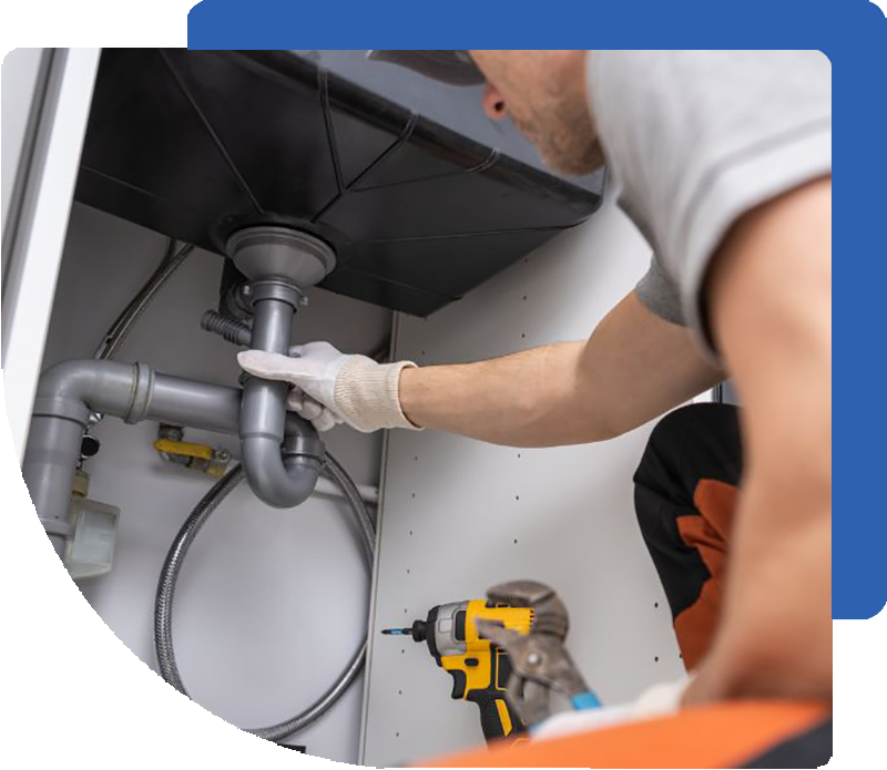 Plumber working under sink on drain pipe.