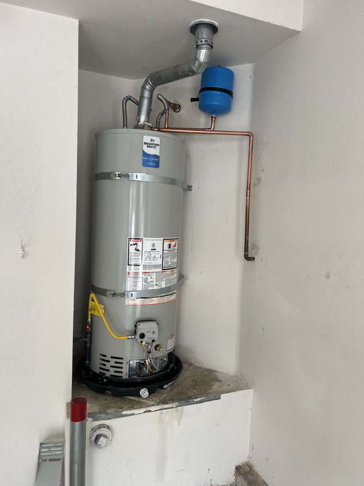 Tankless water heater mounted on wall with copper piping.